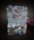 Blue and purple blueberry infused soap with berry and bat motif on top.