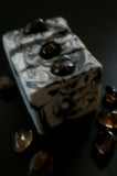 Gray soap with black swirls topped with a smoky quartz crystal