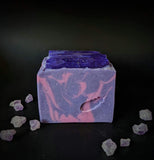 purple soap bar with fuchsia swirls and a purple soap crystals on top with holo glitter