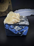 Black soap with periwinkle and white swirls with white ruffle and sparkling soap ball on top