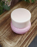 Light pink round conditioner bar scented in black raspberry vanilla pictured with matching shampoo bar