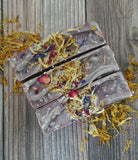 Purple soap with speckles and botanicals on top