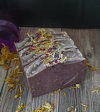 Purple soap with speckles and botanicals on top