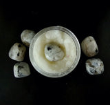 White sugar scrub with ecoglitter and a Moonstone crystal on top.