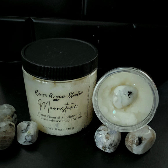 White sugar scrub with ecoglitter and a Moonstone crystal on top, shown in 2 sizes.