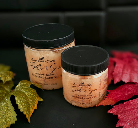 Orange sugar scrub in clear PET jar with black lid.