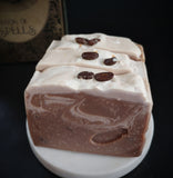 Brown swirled artisan soap made with brewed coffee topped with real coffee beans