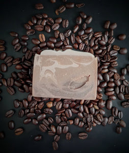 Brown swirled artisan soap made with brewed coffee topped with real coffee beans