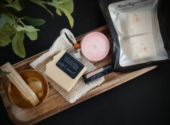 Summer Solstice Celebration Box includes calendula infused soap, sisal soap bag. Celestial citrus shower steamers, strawberry maxi tealight, honey lip balm, palo santo stick, citrine tumble & gold altar bowl