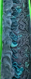 Bar of soap with swirling black and blue patterns with tentacles on top.