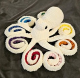 Cream color sparkly octopus with rainbow color suckers.