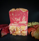 Red soap with gold and copper swirls. Golden acorn and leaf motif on top.