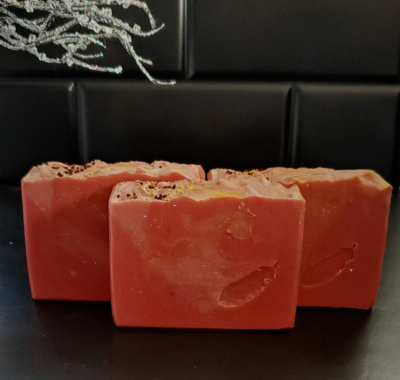 Cranberry artisan soap with gold swirls and cranberry seed and jojoba beads on top