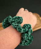 Green crochet hair tie shown on a wrist.