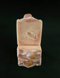 Bars of soap with a golden healer crystal on top a logo on a black. background