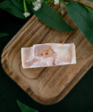 Bar of soap with golden healer crystal on a wooden surface