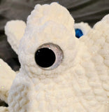 Cream color sparkly octopus with white sparkly hand painted eyes.