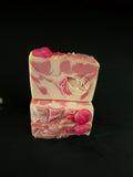 Pink and white soap bar with a leaf design on a black background