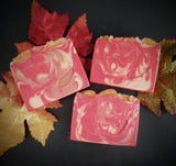 Red soap with gold and copper swirls. Golden acorn and leaf motif on top.
