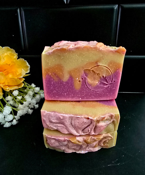 Sunset inspired soap with yellow, orange and pink-purple layers, topped with ecoglitter.