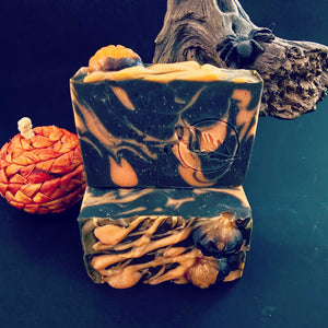 Black bar of soap with pumpkin design on a dark background