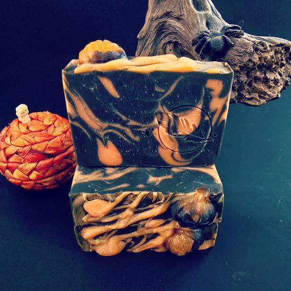 Black bar of soap with pumpkin design on a dark background