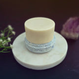 Blue shampoo bar pictured with matching conditioner bar on top.