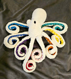 Cream color sparkly octopus with rainbow color suckers.