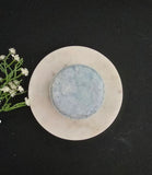 Blue shampoo bar on a dark background.