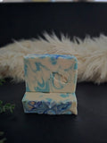 White bar of soap with a decorative blue swirls on a dark surface