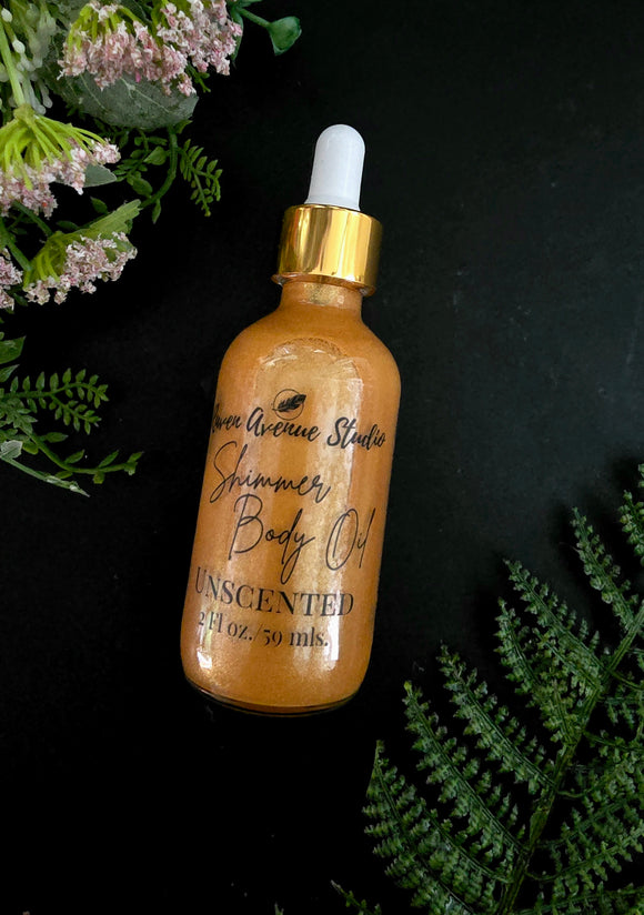 Gold colored shimmer body oil in clear bottle with gold and white dropper.