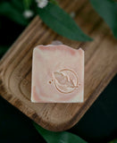 Bar of soap with a leaf design on a wooden board