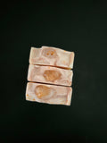 Three soaps samples with embedded crystals on a black background