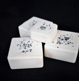 Purify Seal Salt Soap. White soap with black sea salt on top.