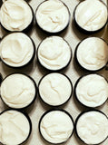 Moon Magick Body Butter. Light gray color body butter in black container.