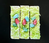 Ostara Coconut Milk Artisan Soap. White soap bar with rainbow speckles, soap grass and eggs on top.