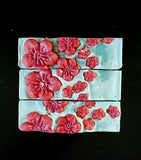 Twisted Cherry Blossom soap. White soap with blue swirl and pink sprinkles with red soap blossoms on top