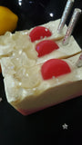 Lunar Lemonade Soap. Red and Yellow ombre with soap pink lemon slices and clear, sparkly stars. Removeable silver glittery straw on top.