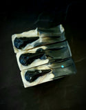 The Raven artisan soap. Black soap with white swirl and black soap raven skull on top