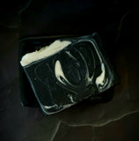 The Raven artisan soap. Black soap with white swirl and black soap raven skull on top