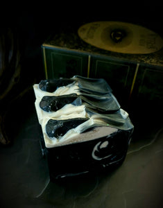 The Raven artisan soap. Black soap with white swirl and black soap raven skull on top