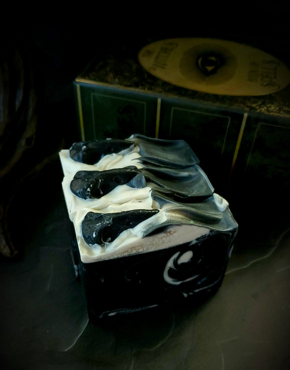 The Raven artisan soap. Black soap with white swirl and black soap raven skull on top