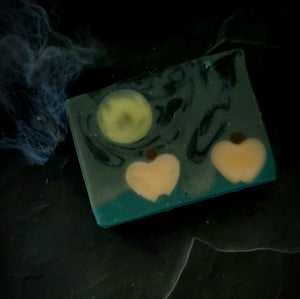 Samhain artisan soap. Grey and black swirl soap with full moon and pumpkin embeds.