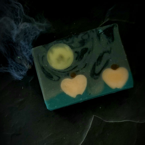 Samhain artisan soap. Grey and black swirl soap with full moon and pumpkin embeds.