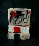 Krampus Artisan Soap. White soap with red and black swirl. Soap present on top.