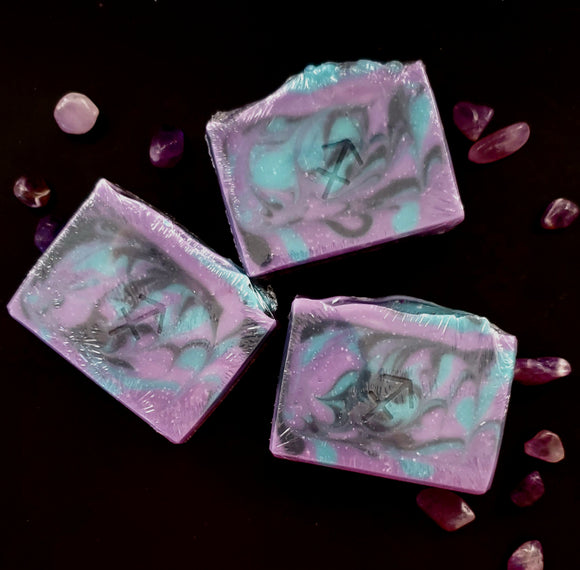 Sagittarius Astrology Soap. Purple soap with black and teal swirls. Sagittarius symbol stamped on front.
