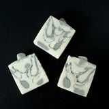 White soap with black and grey swirl, moonstone on top