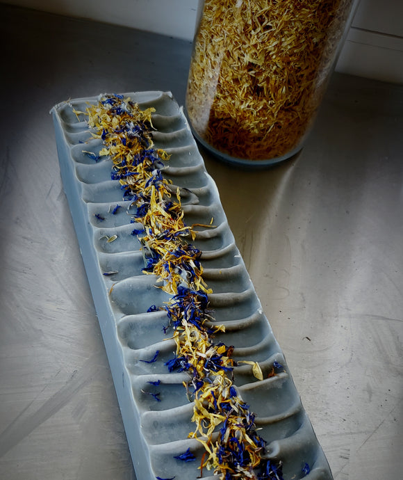 Peaceful Patchouli Soap bar. Blue soap with herbs on top.