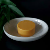 Round turmeric colored face soap bar