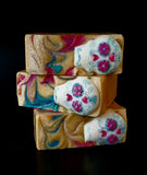 Gold soap with blue and pink swirls, sugar skull on top